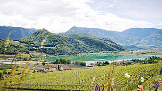 Wunderschöner Ausblick auf ein Panorama bestehend aus Bergen, See und Wald. Südtirol punktet mit seiner Natur im Familienurlaub im Sommer.