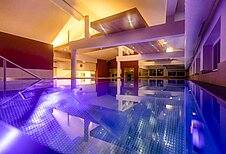 Heaven-Pool mit schöner, lilafarbener Ambienten-Beleuchtung im Familienhotel Galtenberg Family & Wellness Resort in Tirol.