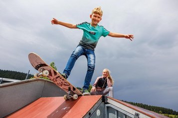 Ein Junge auf einem Skateboard im Skatepark im Familienhotel Elldus Resort im Erzgebirge