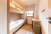 Kinderzimmer mit einem Hochbett und einer Sitzgelegenheit im Familienhotel Das Bayrischzell in Oberbayern.