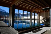 Das Familienhotel Ramsi in Kärnten bietet einen lichtdurchfluteten Indoor Pool mit Panoramablick auf die verschneite Berglandschaft