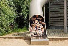 Kinder rutschen und haben viel Spaß auf dem Spielplatz des Familien Wellnes Hotel Seeklause an der Ostsee.