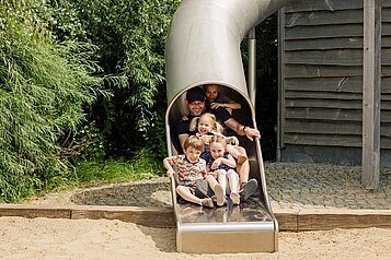 Kinder rutschen und haben viel Spaß auf dem Spielplatz des Familien Wellnes Hotel Seeklause an der Ostsee.