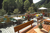 Terrasse im Sommer mit Sonnenschirmen und vielen Sitzmöglichkeiten im Kinderhotel Bruckwirt in Oberösterreich.