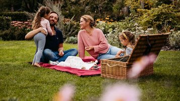 Familie beim Picknick in der Natur auf dem Außengelände des Familienhotels Landhaus Averbeck in der Lüneburger Heide.