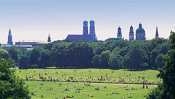 Englischer Garten mit der Skyline von München im Hintergrund.