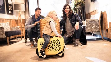 Eltern mit Kleinkind sind mit Koffern in einem Familienhotel angereist.