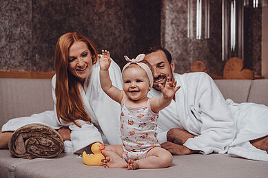 Familie mit Baby entspannt im Ruhebereich im Wellnessurlaub im Familienhotel Huber in Südtirol.