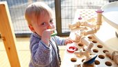 Kleinkind spielt mit Kleinkindgerechten Spielzeug im Familienhotel Monikas Ferienhof