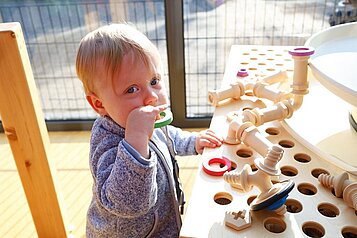 Kleinkind spielt mit Kleinkindgerechten Spielzeug im Familienhotel Monikas Ferienhof