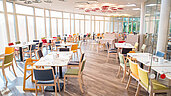 Großes, helles Restaurant mit bunten Stühlen im Familienhotel Kolping Hotel Spa & Family Resort in Ungarn.