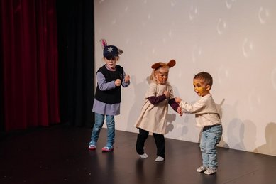 Kinder tanzen verkleidet auf der Bühne bei der Kinderanimation im Familienhotel Amiamo im Salzburger Land.