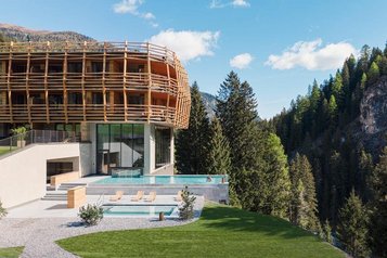 Neubau des Familienhotel Bella Vista in Südtirol mit Infinity Pool, Sonnenterrasse und Blick auf die Berge.