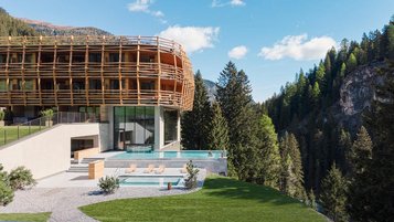 Neubau des Familienhotel Bella Vista in Südtirol mit Infinity Pool, Sonnenterrasse und Blick auf die Berge.