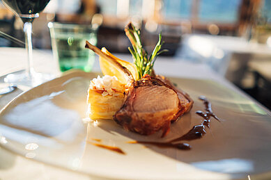 Fleischgericht schön angerichtet auf einem weißen Teller im Restaurant des Familienhotels Kirchheimerhof in Kärnten.