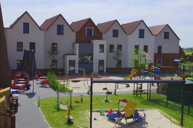 Luftaufnahme des Familienhotels Deichkrone an der Nordsee im Sommer. Das Familienhotel befindet sich in unmittelbarer Nähe zum Strand.