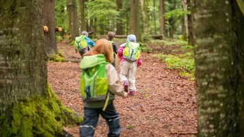 Gastkinder des Familienhotels Landhaus zur Ohe gehen mit Ihrem Betreuer in des Wald und erkunden die Landschaft.