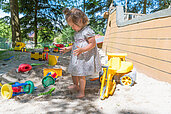 Kind spielt mit vielen Sandförmchen im Sandkasten im Familienhotel Ulrichshof im Bayerischen Wald