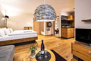 Geräumiges Familienzimmer mit Doppelbett, Sofa und kleiner Küchenzeile im Familienhotel Sonnenpark.