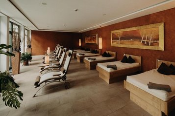 Liegen stehen im Ruheraum des Wellnessbereichs im Hotel Sonngastein im Salzburger Land für erholsame Auszeiten bereit.
