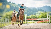 Mädchen beim Reiten im Landgut Furtherwirt mit Blick auf die Berge