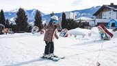 Kind lernt in der Skischule vor dem Familienhotel Amiamo in Zell am See das Skifahren