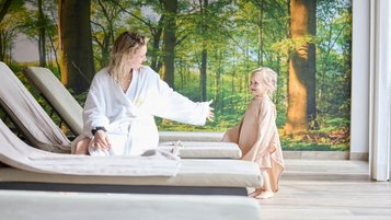 Mutter und Kind genießen entspannte Wellnesszeit im Familienhotel Das Bayrischzell mit gemütlichen Liegen.