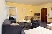 Zimmer mit Sofa und Couchtisch im 2 Raum Zimmer im Familienhotel Sonnenhügel in der Rhön.