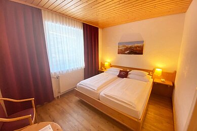 Ein Doppelzimmer im Hotel Alpengasthof Hochegger mit Doppelbett und Panoramabild über dem Bett.