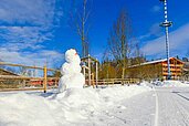In winterlicher Landschaft steht ein Schneemann auf dem Hof des Familienhotels Ulrichshof Nature · Family · Design.