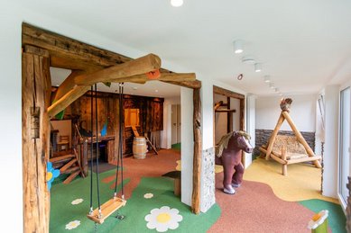 Liebevoll gestalteter Indoor-Spielbereich mit Holzschaukel, Kletterelementen und Spielpferd im Hotel Engel im Schwarzwald