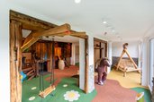 Liebevoll gestalteter Indoor-Spielbereich mit Holzschaukel, Kletterelementen und Spielpferd im Hotel Engel im Schwarzwald