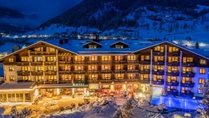 Das Familienhotel Kirchheimerhof in Kärnten, umgeben von einer großen Hotel-Außenanlage und winterlichen Berglandschaft.