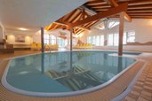 Hallenbad mit Holzdecke und Liegen im Landgut Furtherwirt für entspannten Badespaß