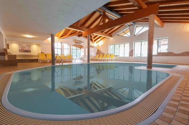 Hallenbad mit Holzdecke und Liegen im Landgut Furtherwirt für entspannten Badespaß