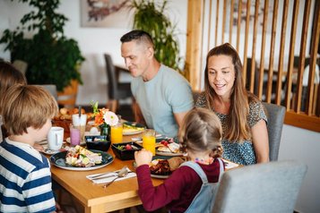 Familie genießt ein gemeinsames Frühstück mit frischen Speisen im Familien Resort Petschnighof in Kärnten.