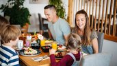 Familie genießt ein gemeinsames Frühstück mit frischen Speisen im Familien Resort Petschnighof in Kärnten.