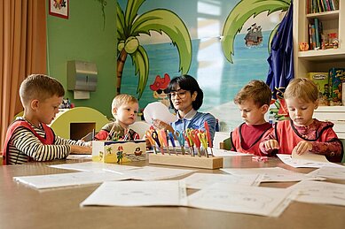 Betreuerin bastelt mit den Kindern im Happy-Club des Familienhotels Seeklause an der Ostsee.