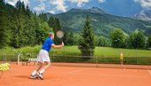 Tennisplatz beim Hotel Sonngastein im Salzburger Land mit spielender Person und Blick auf die Berge.