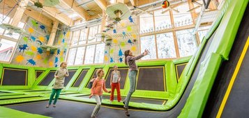 Ein paar Kinder im Trampolinpark beim Basketballspielen im Familienhotel Feldberger Hof im Schwarzwald 