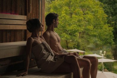 Eltern entspannen in der Sauna des Familienhotels Engel Gourmet und Spa mit Ausblick ins Grüne.