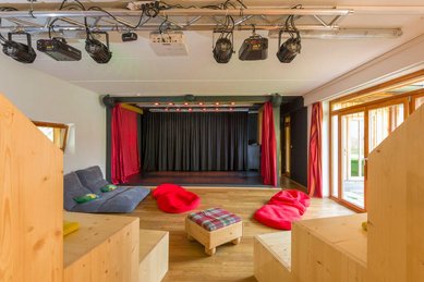 Bunte Bühne mit gemütlichen Sitzmöglichkeiten für kleine und große Auftritte im Familienhotel Ramsi