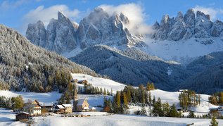 Ein Dort im Winter in einer Berglandschaft.