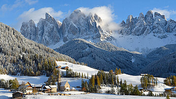 Ein Dort im Winter in einer Berglandschaft.