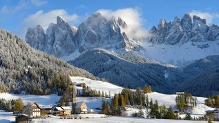 Ein Dort im Winter in einer Berglandschaft.