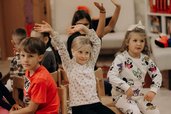 Kinder sitzen und spielen gemeinsam in der Kinderbetreuung im Happy-Club des Hotel Sonngastein im Salzburger Land.