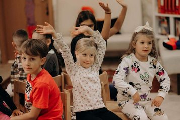 Kinder sitzen und spielen gemeinsam in der Kinderbetreuung im Happy-Club des Hotel Sonngastein im Salzburger Land.