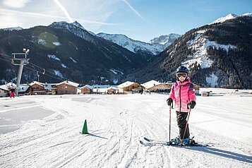 Mädchen auf einer Skipiste in der Nähe des Almfamilyhotels Scherer in Tirol.
