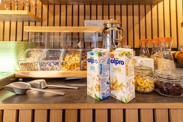 Frühstücksbuffet im Familienhotel Ottonenhof mit Müsli, Obst und pflanzlichen Milchalternativen.