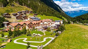 Luftaufnahme im Sommer vom Familienhotel Alphotel Tyrol Wellness & Family Resort in Südtirol.